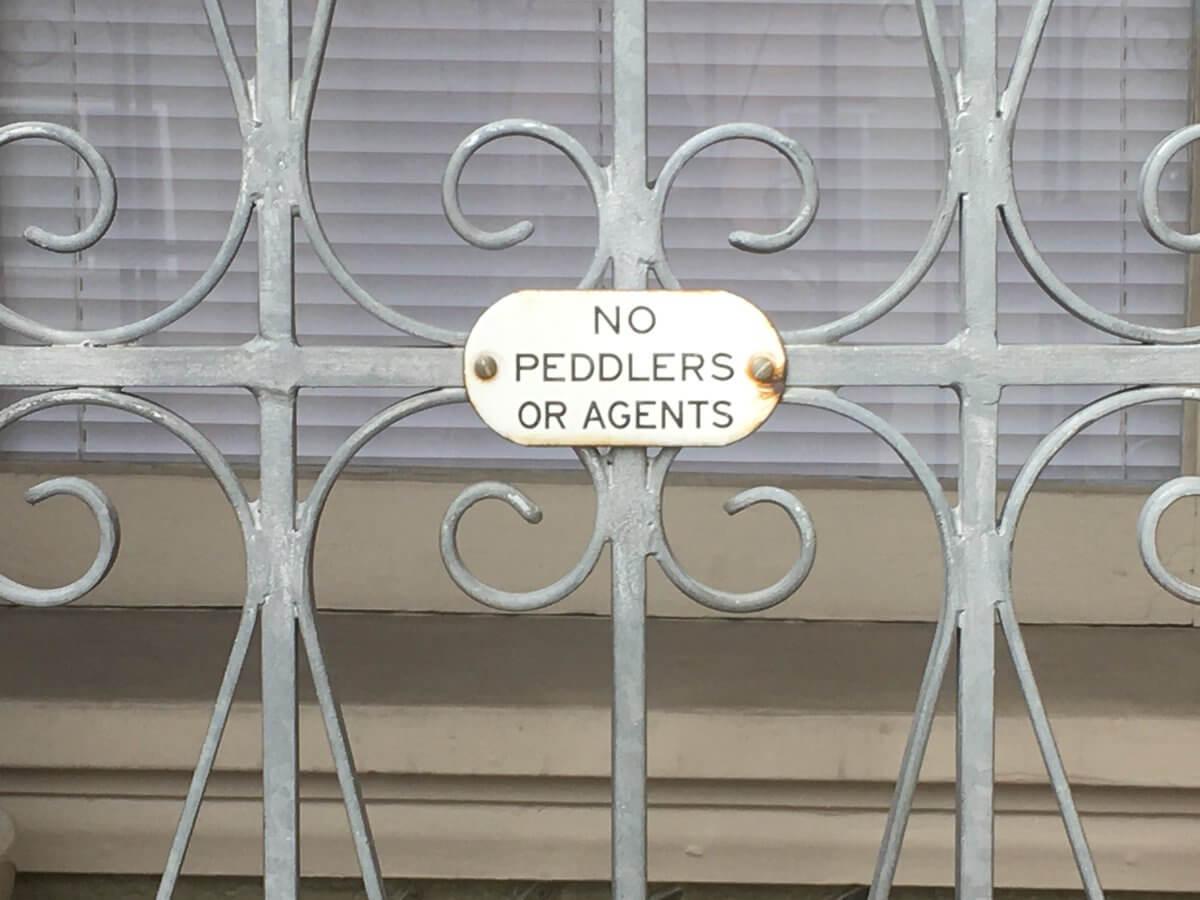 a gated door with a sign saying no peddlers or agents